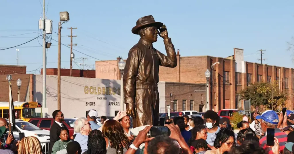 People taking pictures with the Emmett Till's statue stands tall
