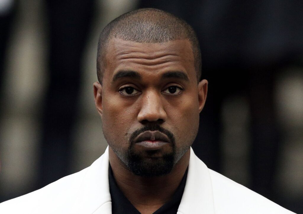 Kanye West wearing a white coat