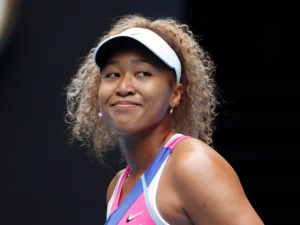 A woman with curly hair wearing a visor.