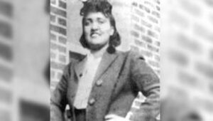 A black and white photo of a woman in a suit.