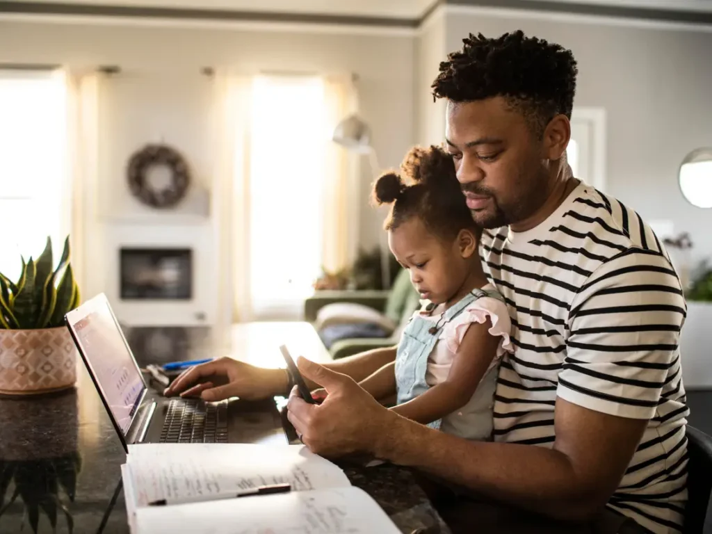 A man and child are looking at their phones.