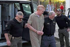 A man in prison is being escorted by two police officers.