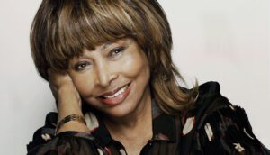 A woman with brown hair and bangs smiles.