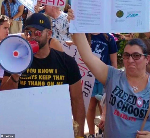 A man and woman holding up signs while standing next to each other.