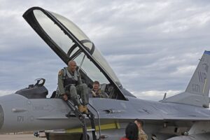 A man sitting on the wing of an airplane.