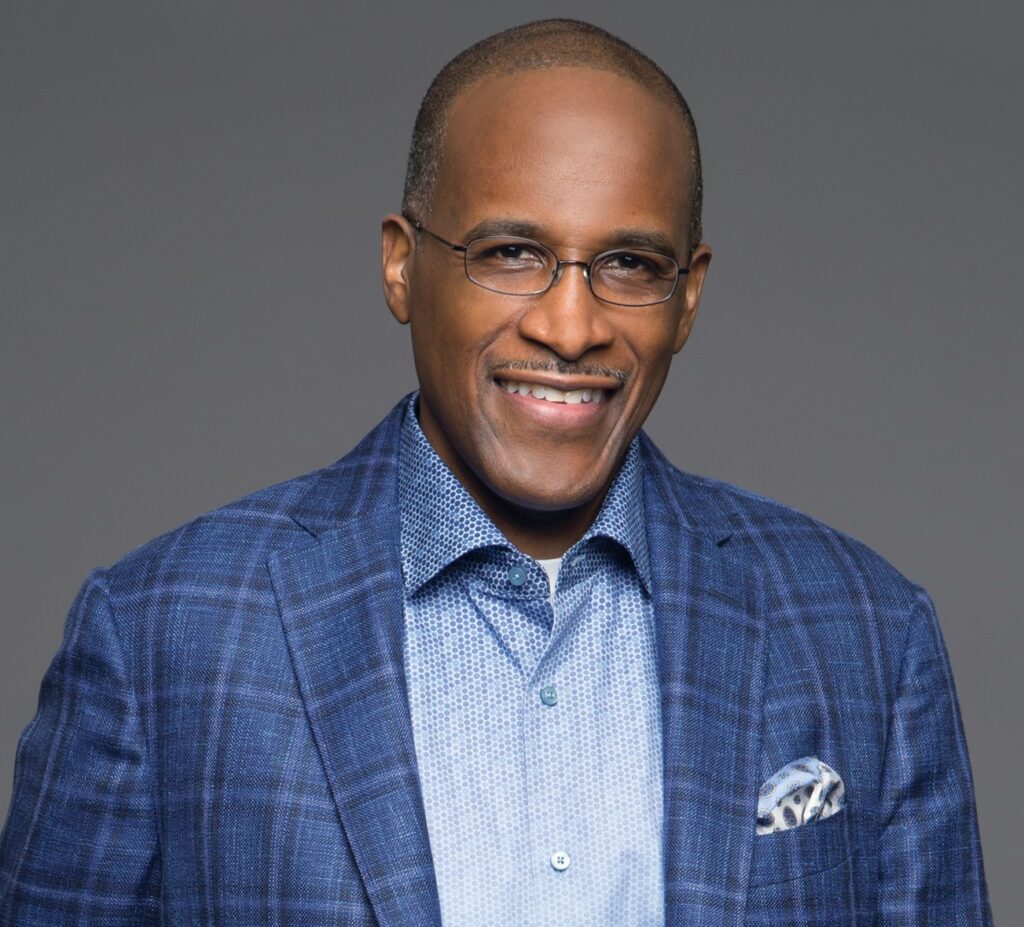 A man in a blue suit and glasses.