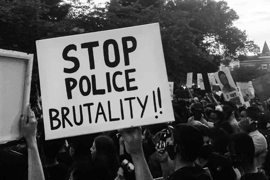 A black and white photo of people protesting in the street.