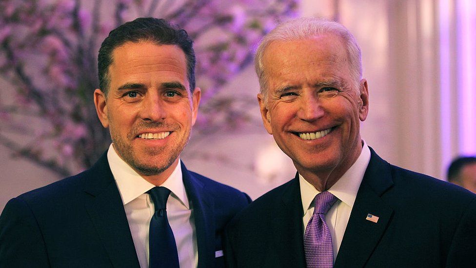 Two men in suits and ties smiling for a picture.