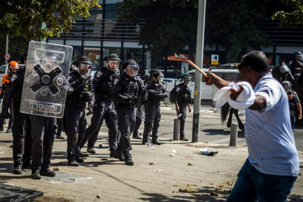 A group of people standing around in front of police.