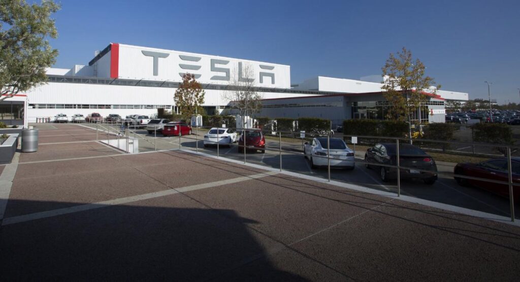 A large white building with cars parked in front of it.