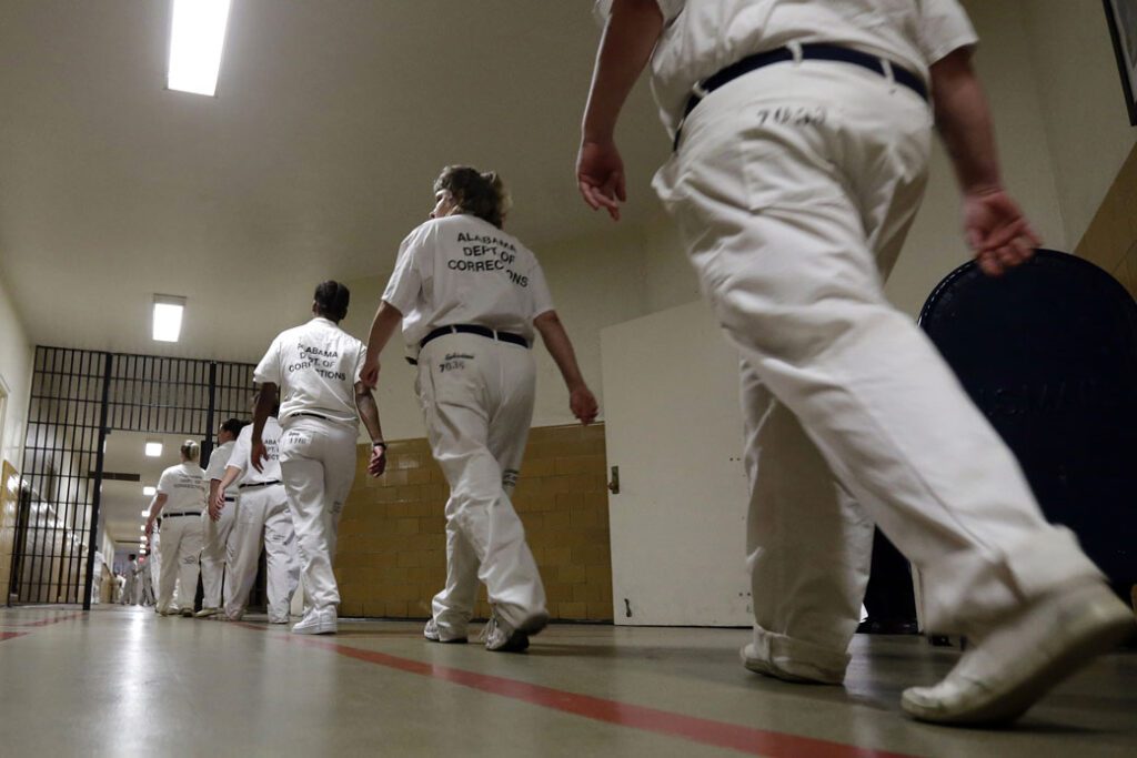 A group of people in white uniforms walking down the hall.