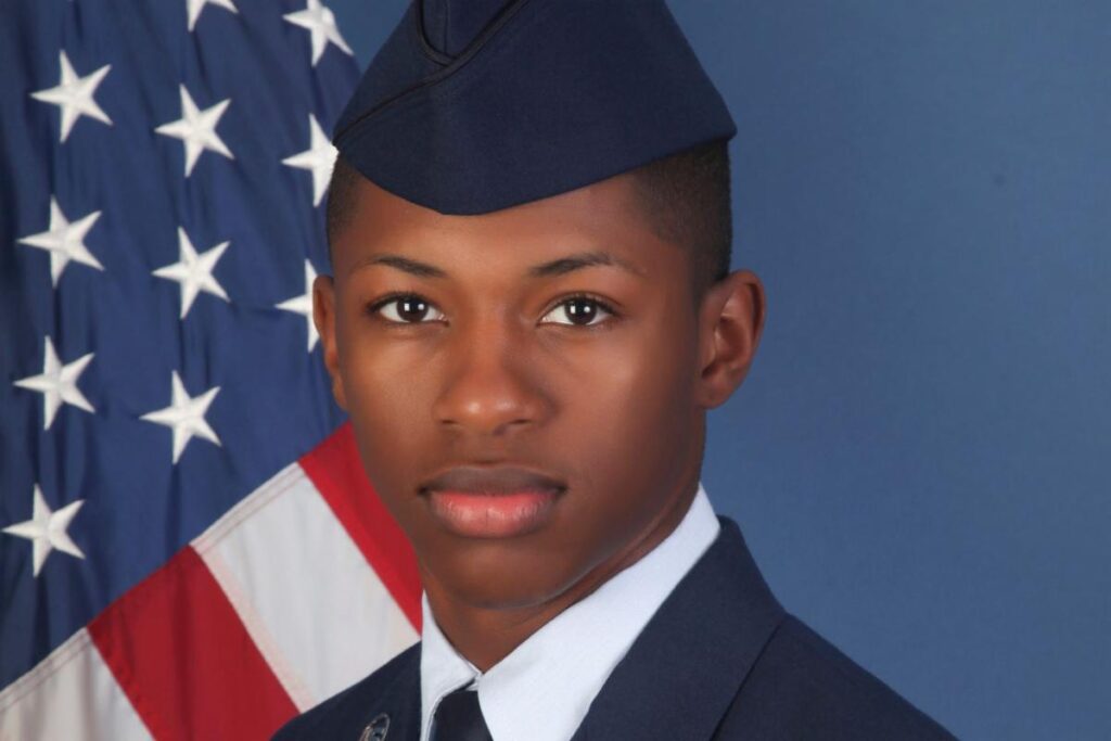 Young man in military uniform with US flag.