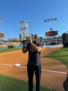 Man holding World Series trophy on baseball field.