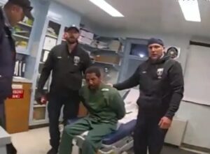 Handcuffed man beaten by prison guard and nurse.